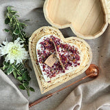 Große herzförmige Kerze mit Rosenblättern in einer Holzherz-Geschenkbox