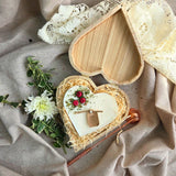 Draufsicht auf Herzkerze mit roten Beeren in einer Holz-Geschenkbox