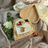 Nahaufnahme von roten Beeren-Herzkerze in umweltfreundlicher Holzbox