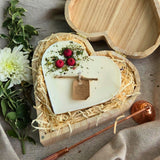 Große herzförmige Kerze mit roten Beeren in einer Holzherz-Geschenkbox