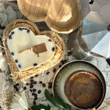 Nahaufnahme von handgemachter Herzkerze mit Kaffeebohnen in Holzbox, Landhausstil